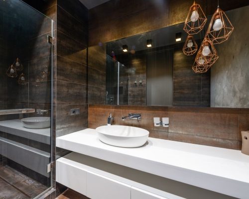 A sleek modern bathroom featuring pendant lighting and a contemporary sink.